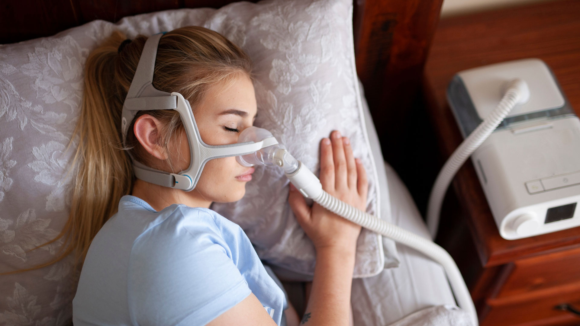 a young woman wearing a CPAP mask while sleeping